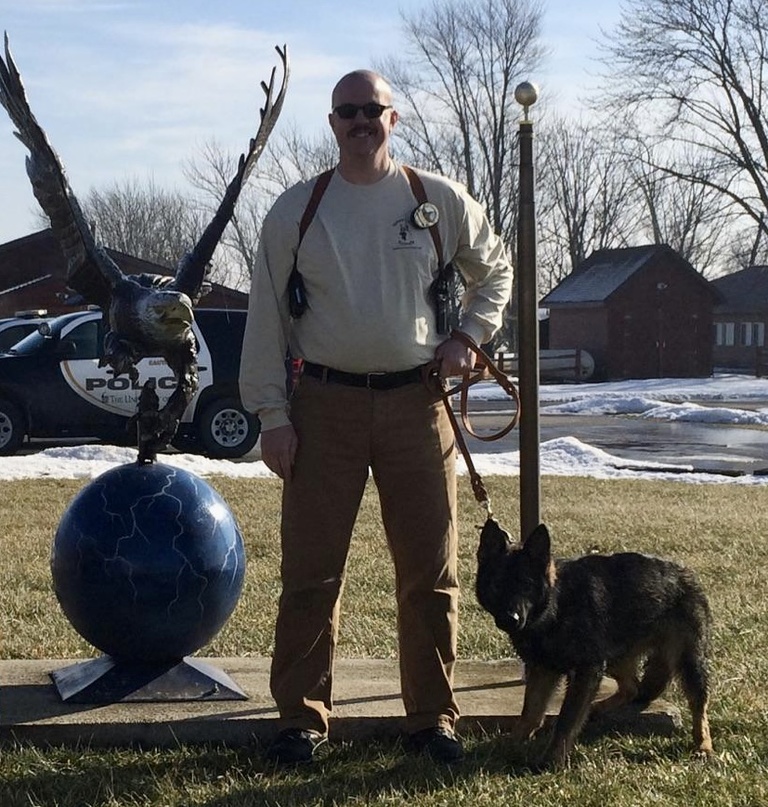 Officer Bernhard poses with K9 Jago as a puppy.